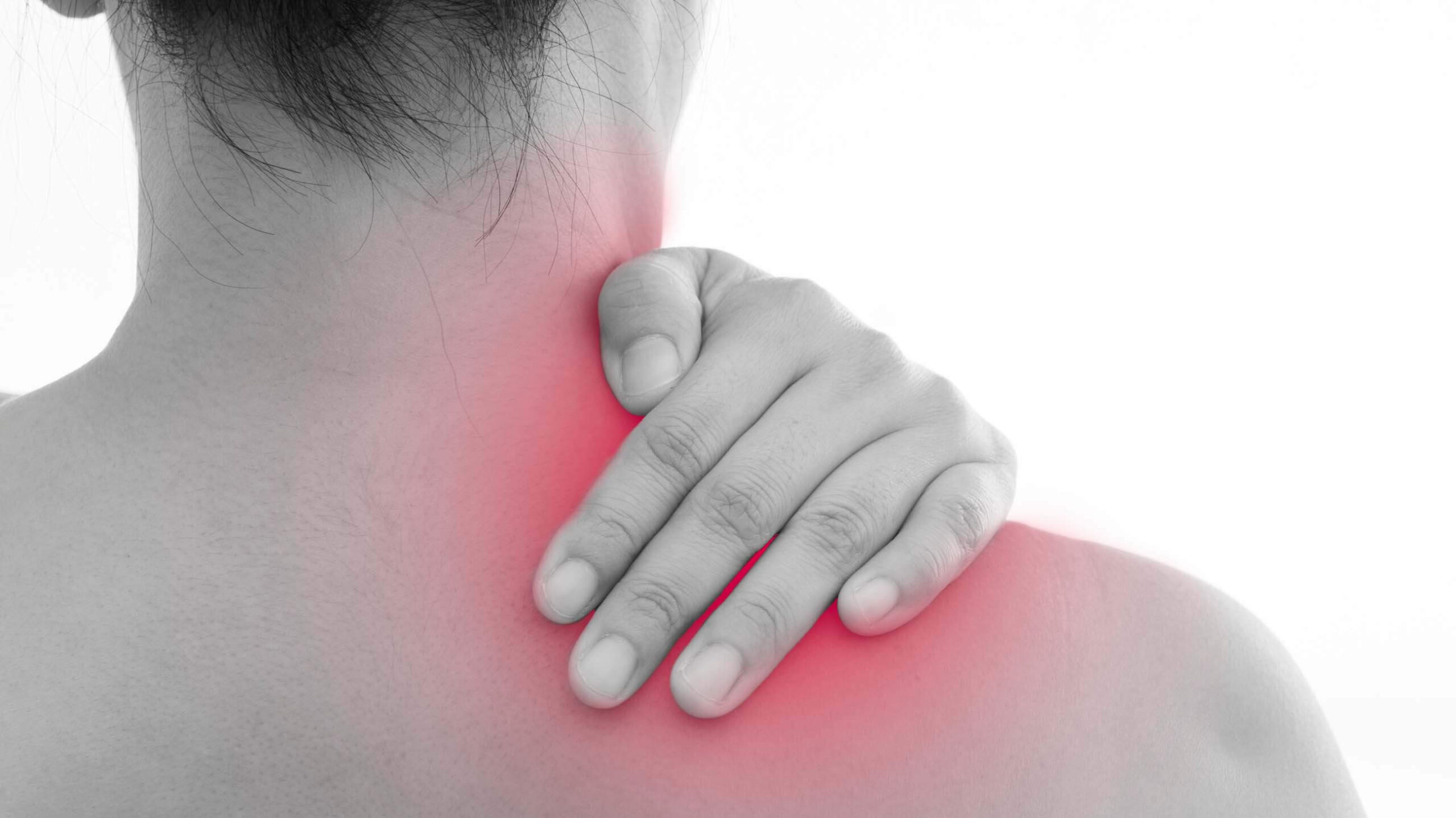 woman holding shoulder swollen red with pain