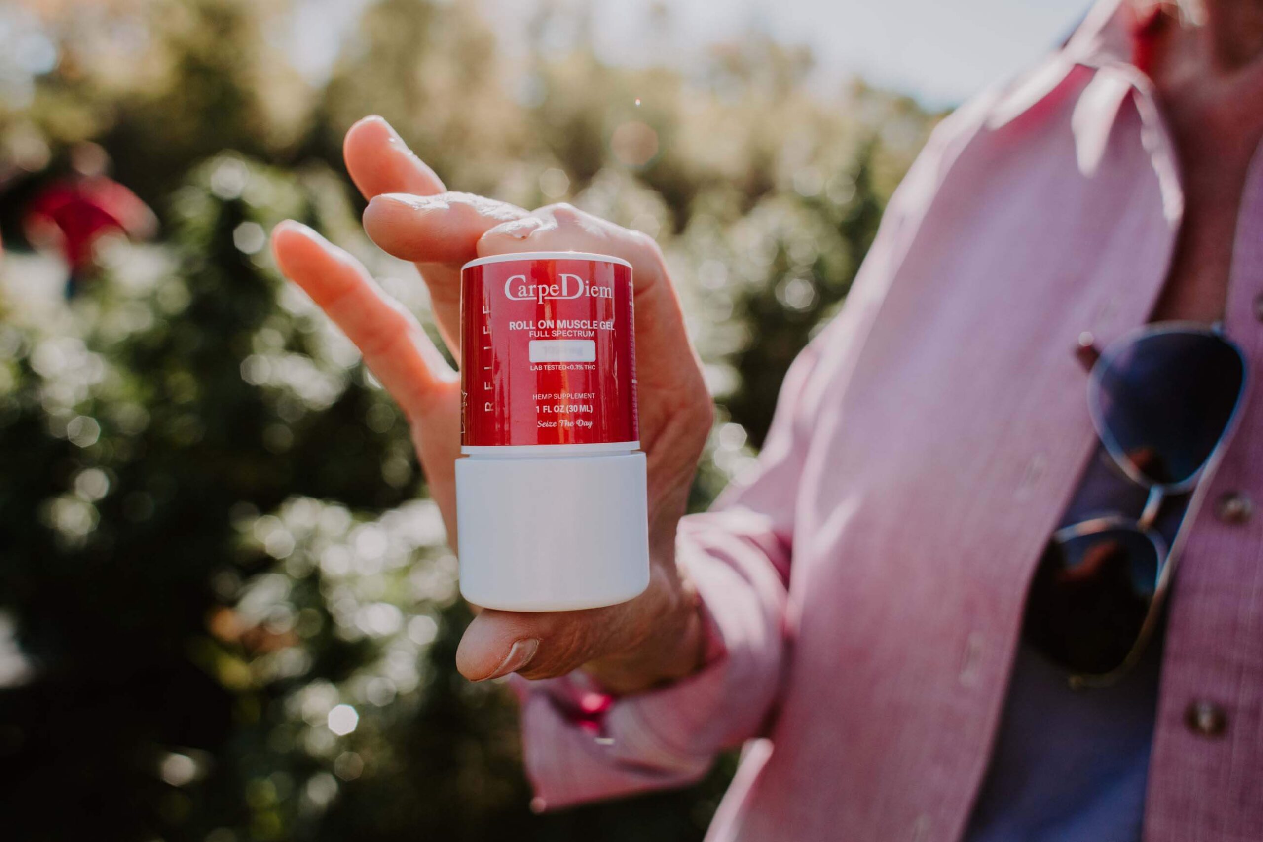 woman holding Carpe Diem gel roll-on