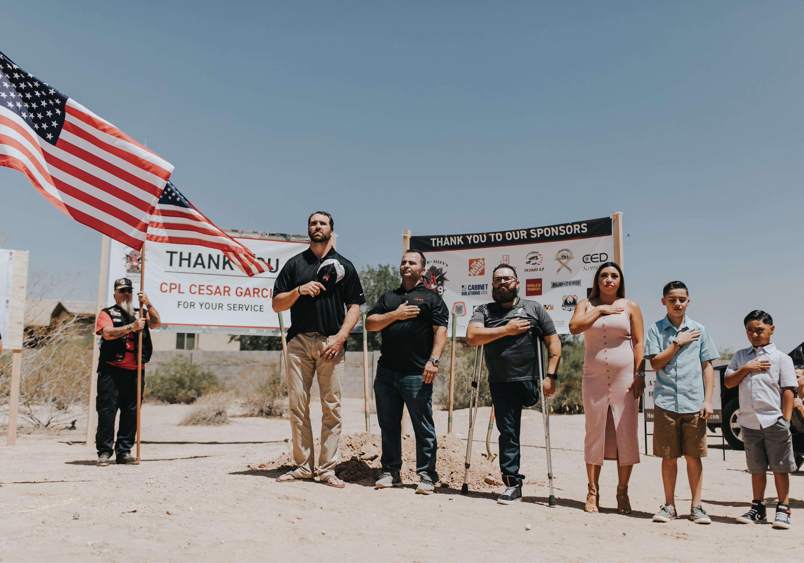 Veterans standing for a pledge of allegiance at ground breaking ceremony